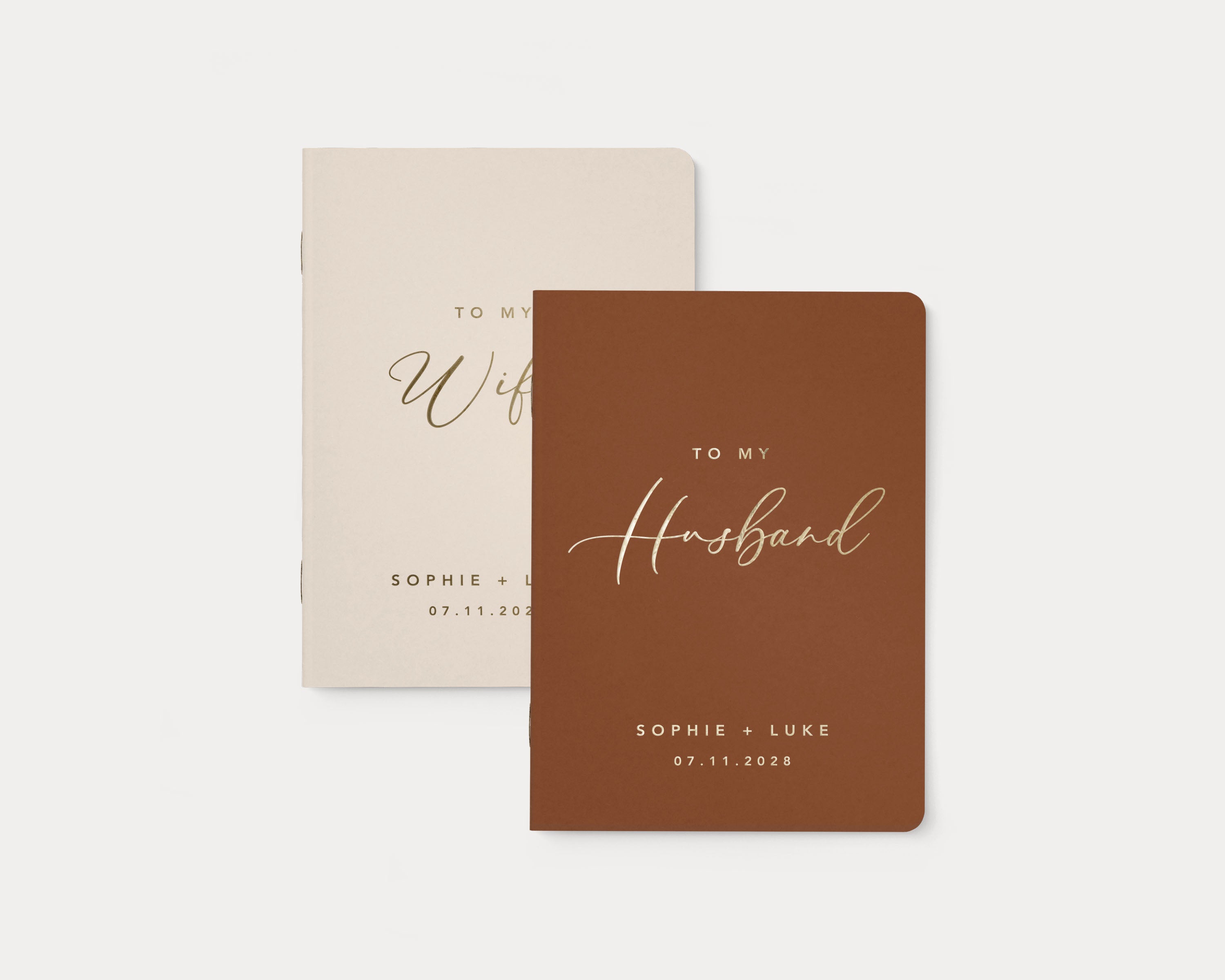 Ivory and terracotta wedding vow books with custom gold foil lettering.
