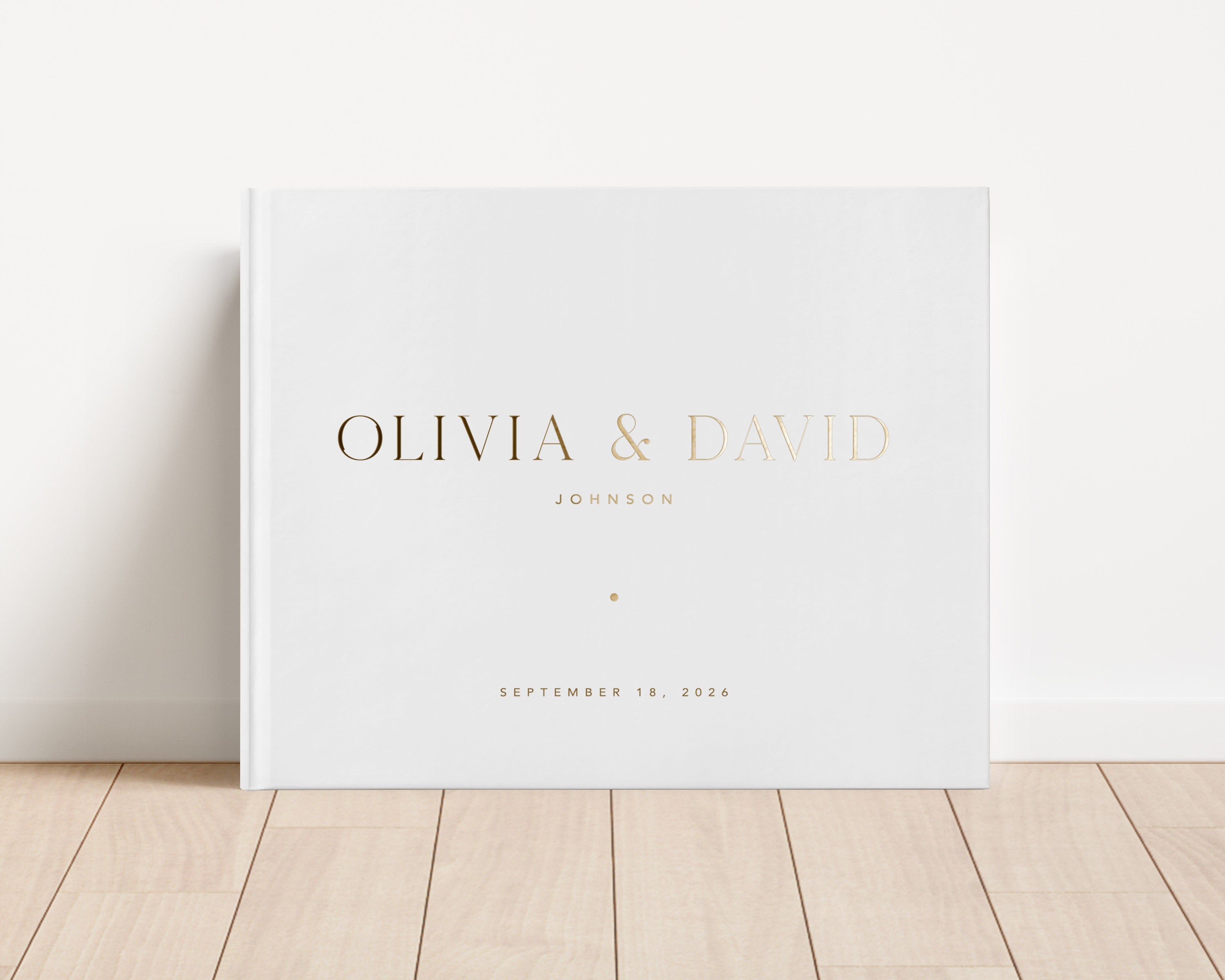 Luxury wedding guest book with custom gold foil text and white hardback cover.