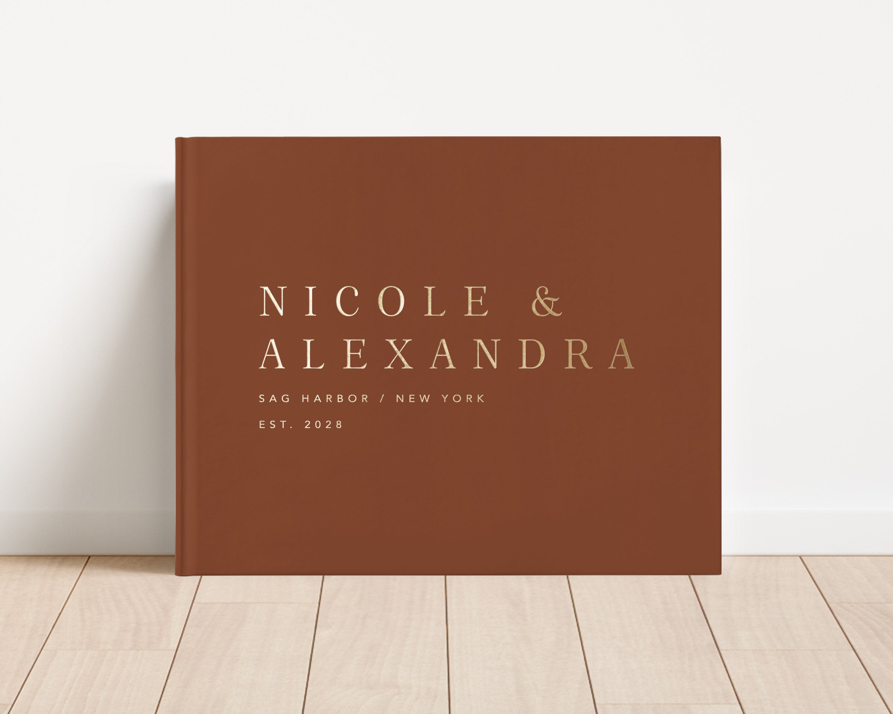 Luxury wedding guest book with custom gold foil text and terracotta hardback cover.