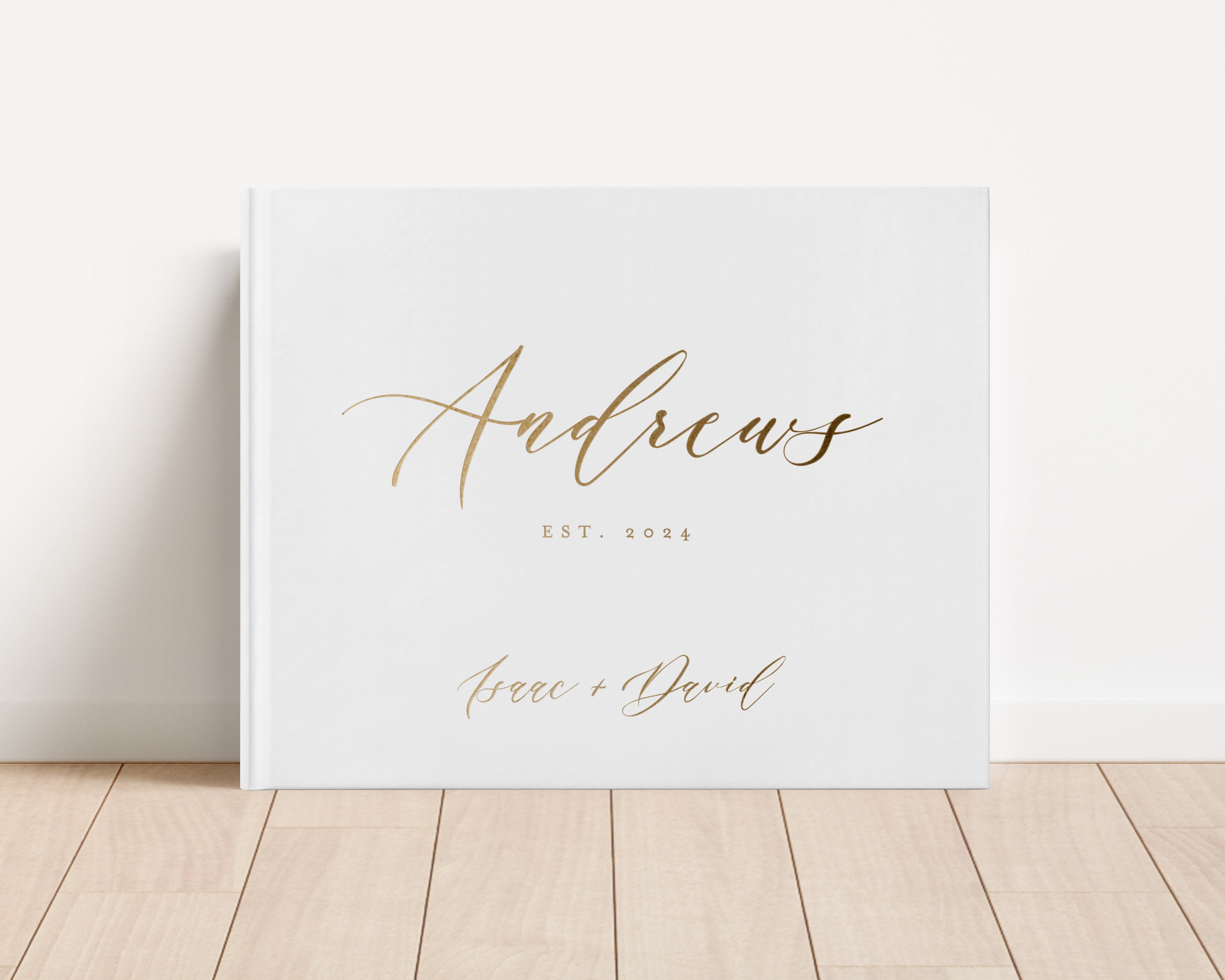 Luxury wedding guest book with custom gold foil text and white hardback cover.